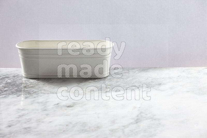 An empty white plant pot on grey marble background