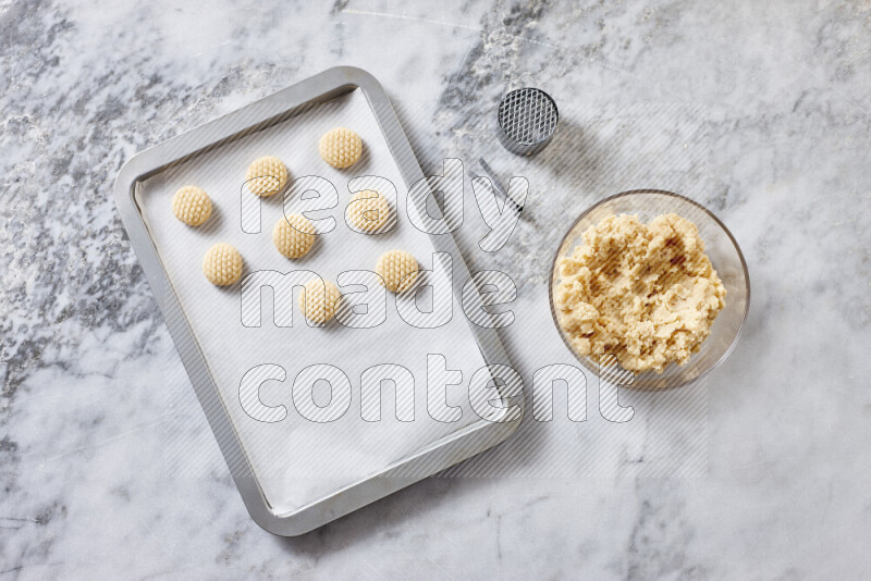 Kahk step by step with its ingredients ghee, sugar, flour, sesame, yeast, water and kahk flavor on grey marble background