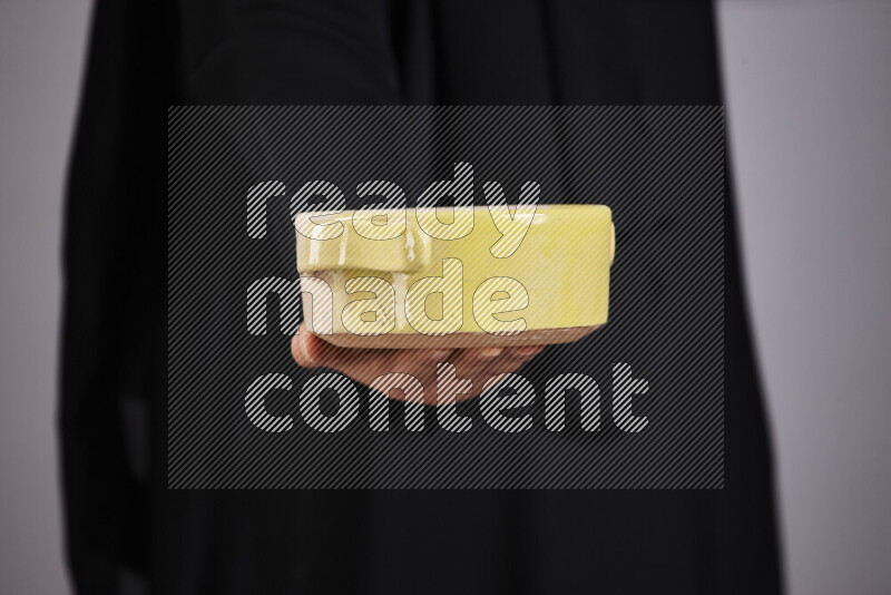 A woman in black abaya holding different pottery essentials in different positions