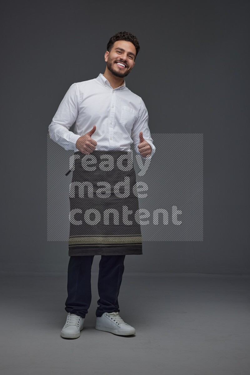 A man wearing smart casual and apron standing and making multi poses eye level on a gray background