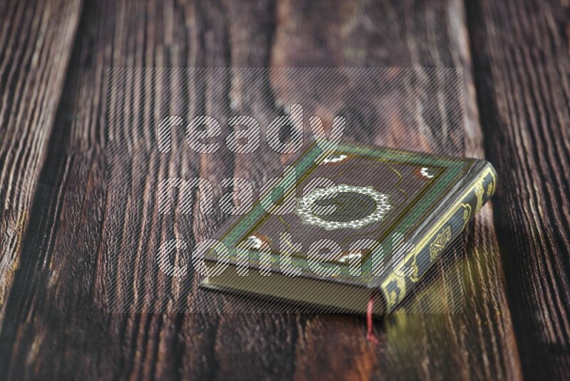 Quran with a prayer beads on wooden background