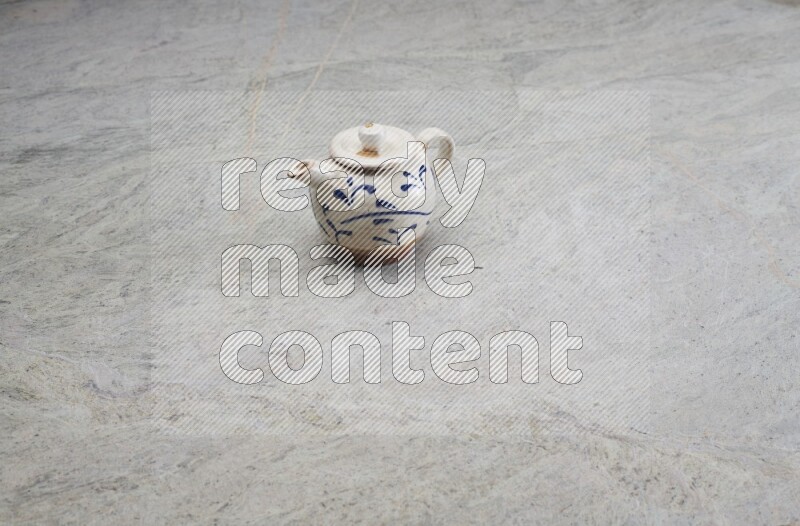 A pottery teapot on grey marble background
