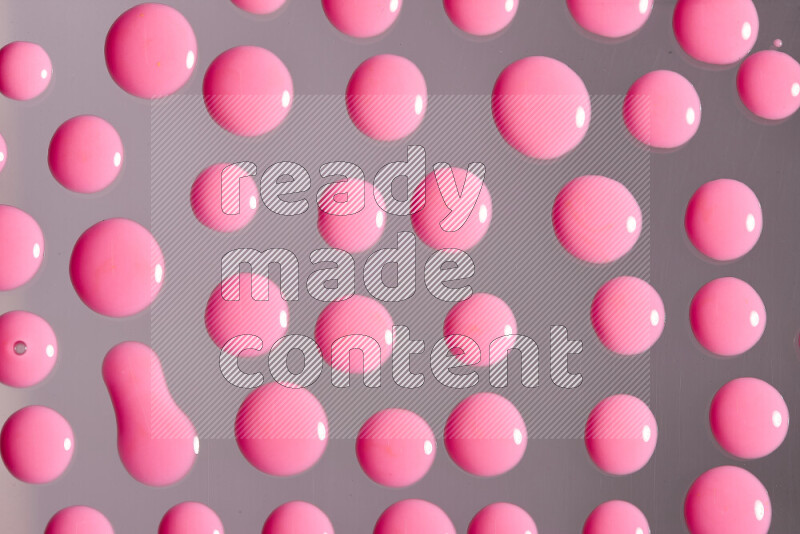 لقطات مقربة لقطرات من اللون الوردي على الخلفية