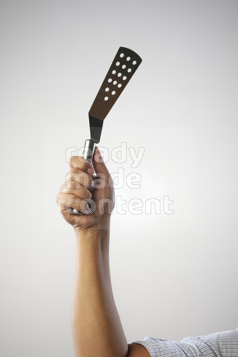 Male Hand Holding Burger Flipper on white background