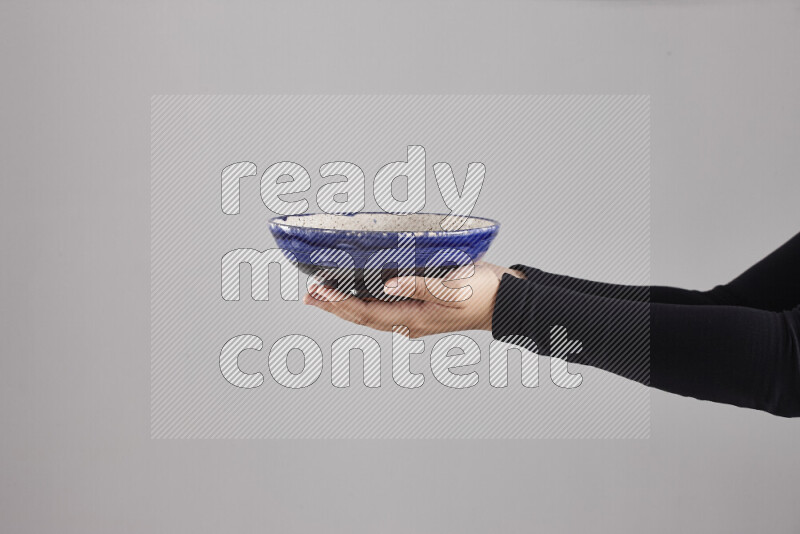 A woman in black abaya holding different pottery essentials in different positions