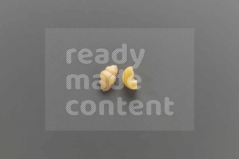 Snails pasta with other types of pasta on grey background