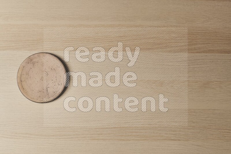 A pottery coaster on light wooden background