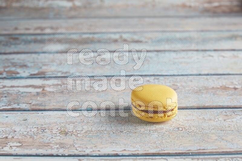 45º Shot of Yellow Lemon macaron on light blue wooden background