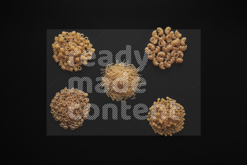 Different pasta types in bunches on black background