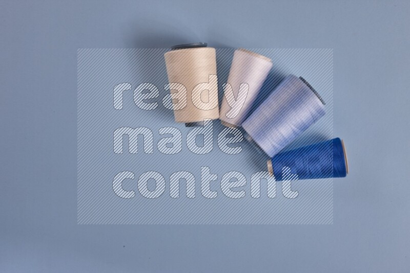 A white collection of sewing and tailoring tools arranged on a blue background