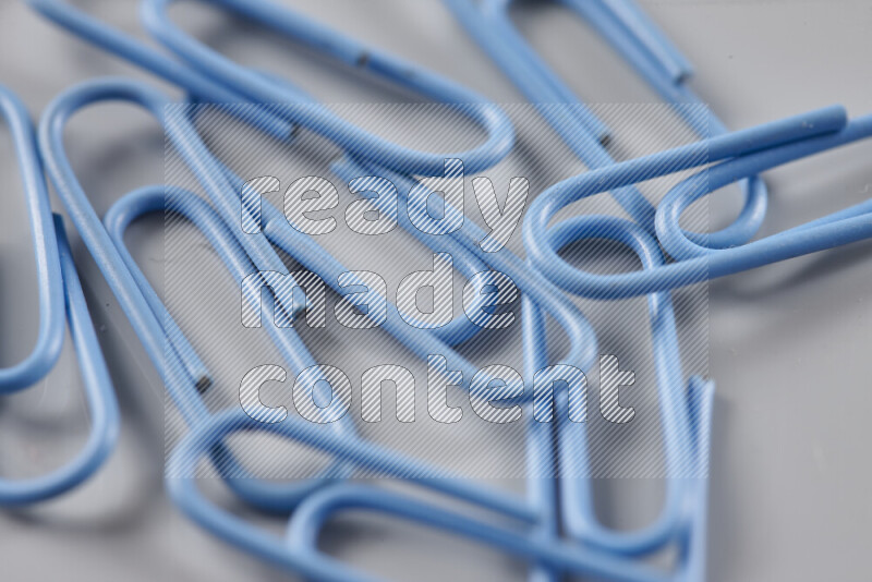 Blue paper clips isolated on a grey background