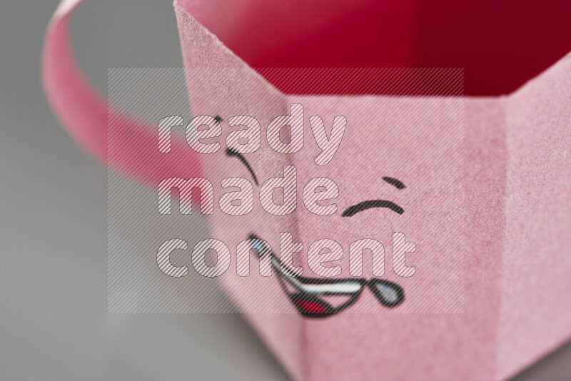 Origami cup on grey background