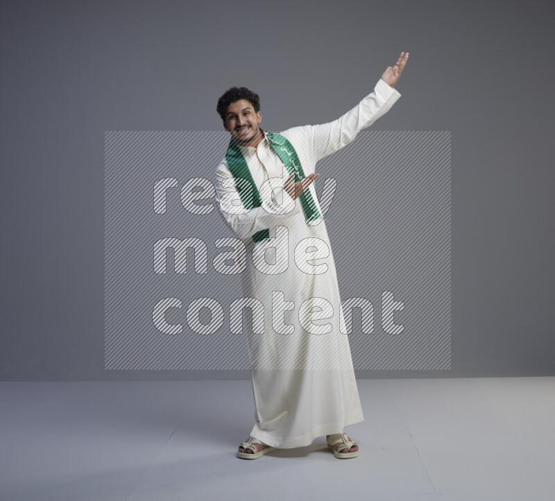 رجل سعودي يرتدي ثوب ابيض و شال يتفاعل مع الكاميرا