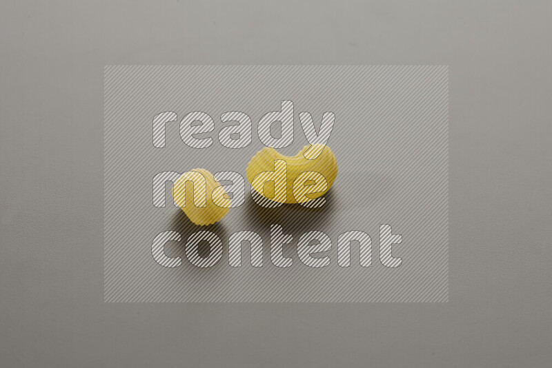 Big rings pasta with other types of pasta on grey background