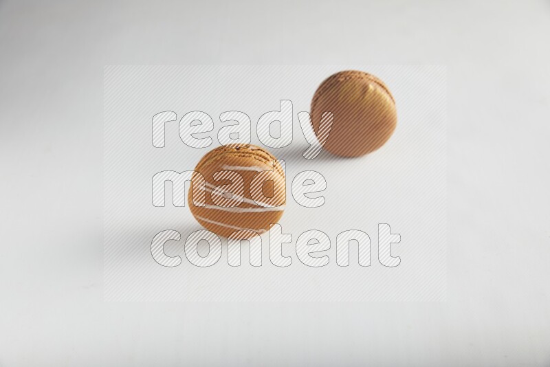 45º Shot of of two assorted Brown Irish Cream, and Brown Coffee macarons  on white background