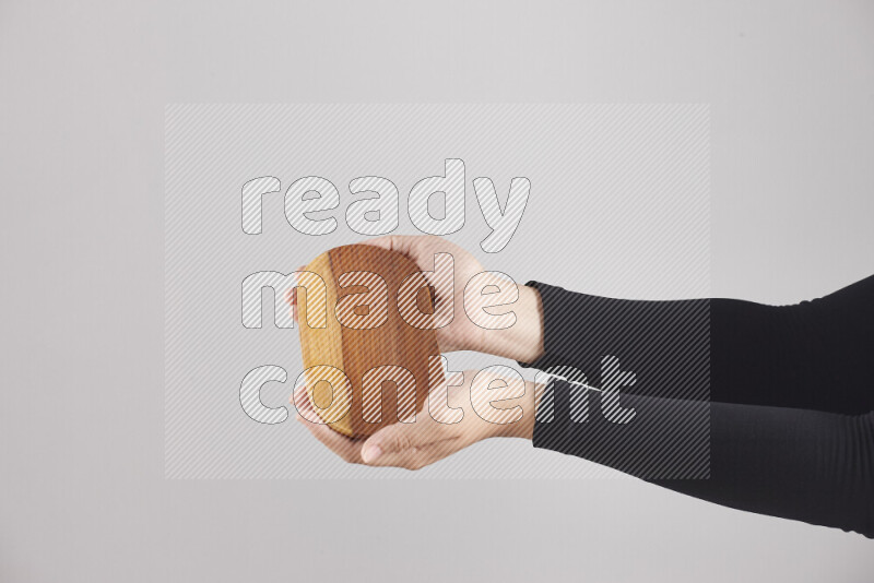 A woman in black abaya holding different wooden essentials in different positions