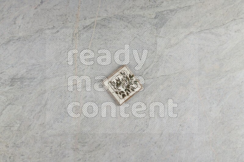 A decorative pottery coaster on grey marble background