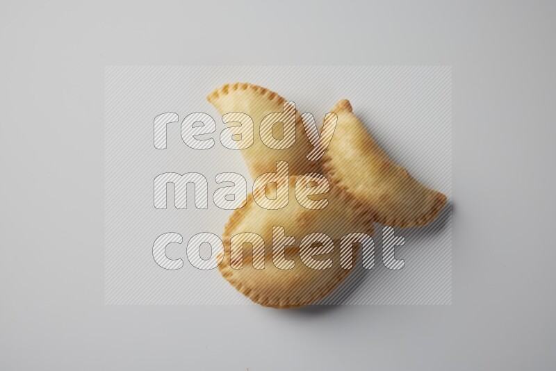Four fried sambosa from a top angle on a white background