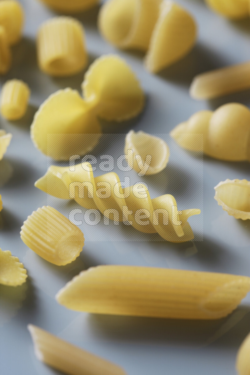 Different pasta types on light blue background