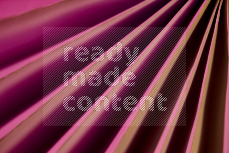 صورة تقدم نمط تجريدي ورقي من الخطوط المائلة بدرجات اللون الوردي والذهبي