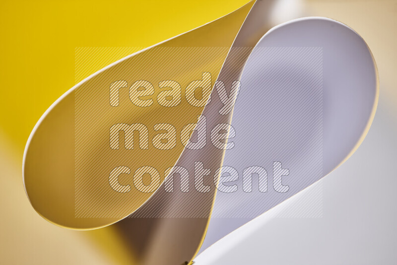 An abstract art of paper folded into smooth curves in white and yellow gradients