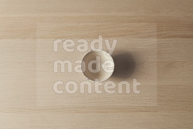 A white pottery bowl on light wooden background