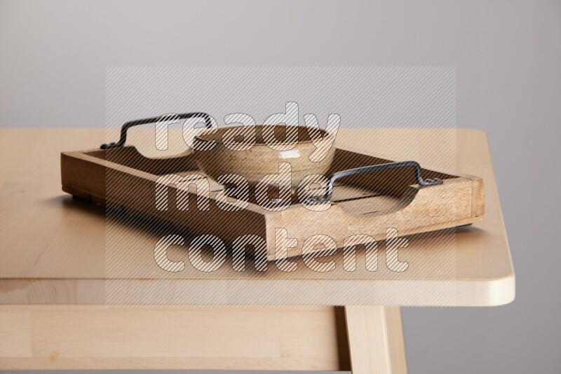 multi colored  bowl on a light colored rectangular wooden tray with handles