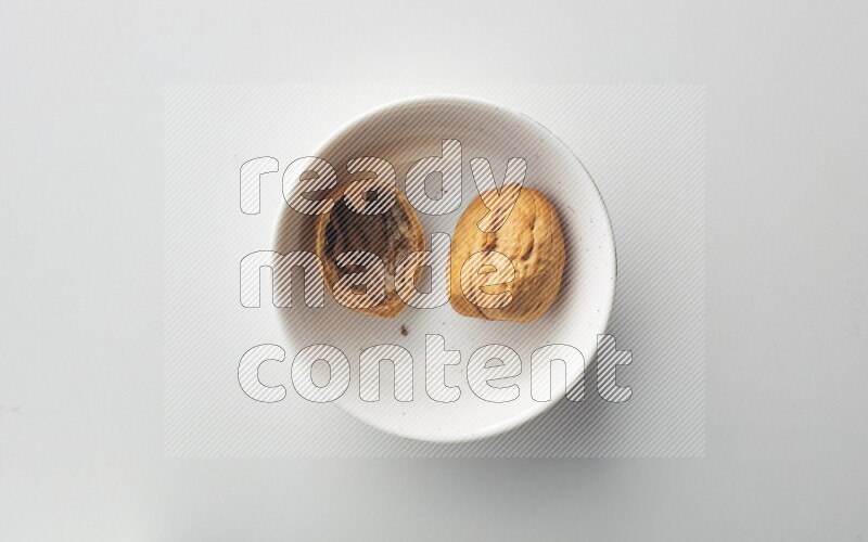 Top-view shot of walnut in a container on white background
