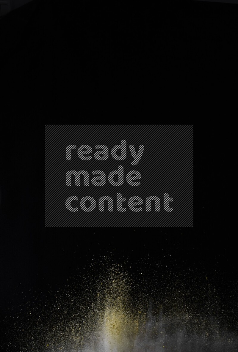 A side view of yellow powder explosion on black background