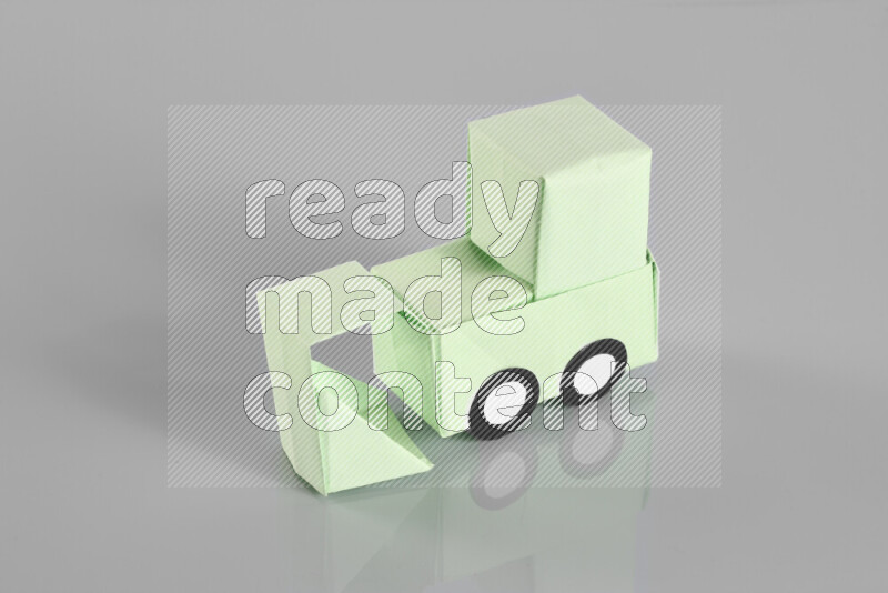 Origami bulldozer on grey background