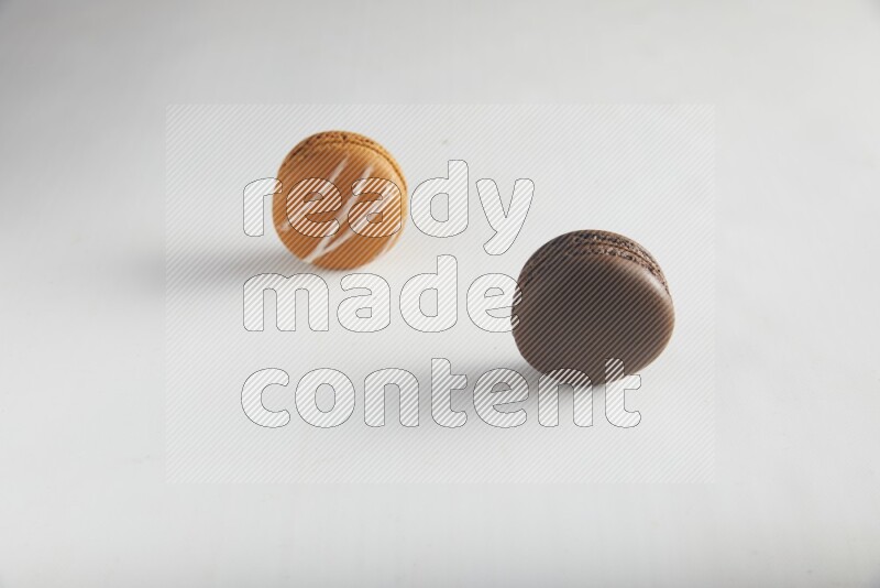 45º Shot of of two assorted Brown Irish Cream, and Brown Dark Chocolate macarons on white background