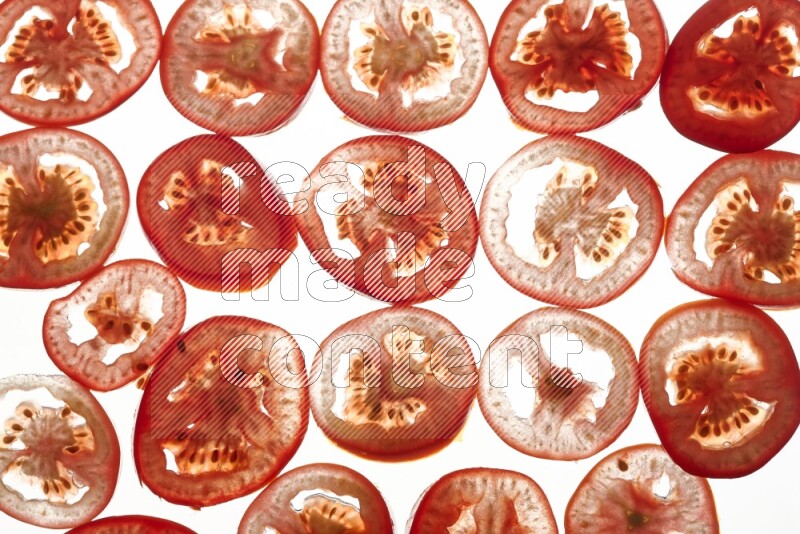Tomatoes slices on illuminated white background