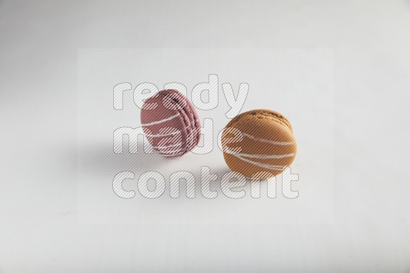 45º Shot of of two assorted Brown Irish Cream, and Red Poppy Flower macarons on white background