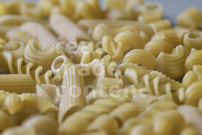Different pasta types on light blue background