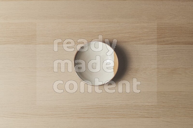 A multicolored pottery plate on light wooden background
