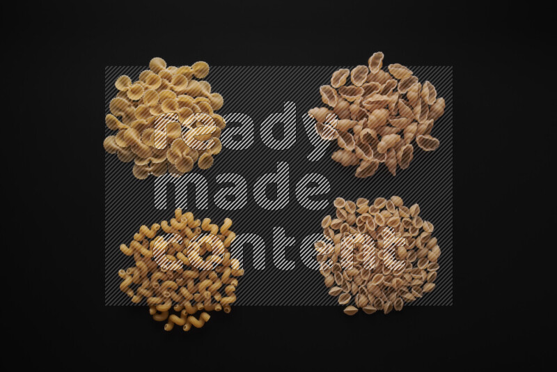 Different pasta types in bunches on black background