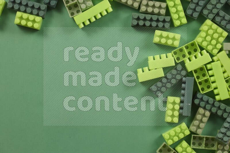 Green plastic building blocks on green background (kids toys)