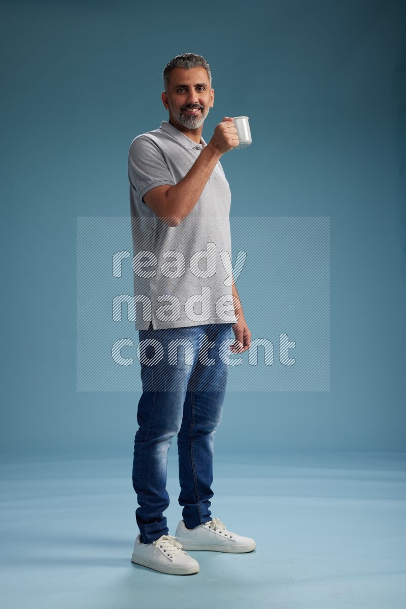 Man Standing drinking coffee on blue background