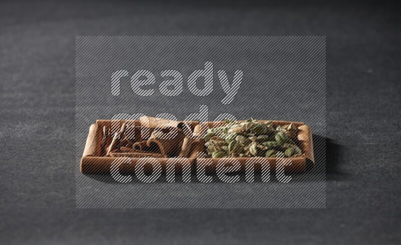 2 squares of cinnamon sticks full of cardamom and cinnamon on black flooring