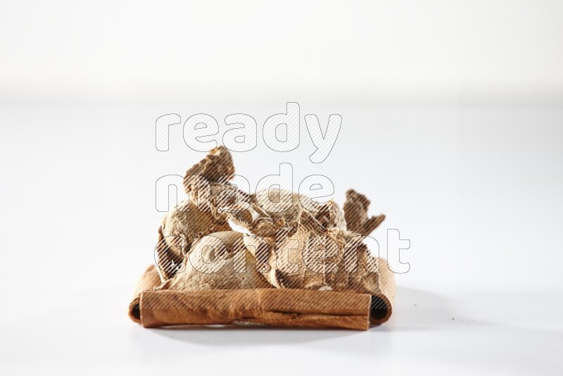 A single square of cinnamon sticks full of dried ginger on white flooring