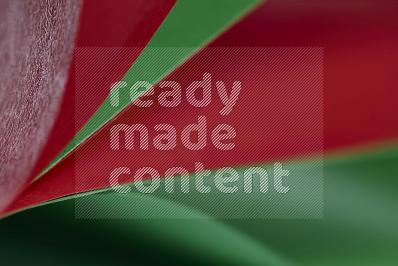 An abstract art showing red and green paper sheets arranged in an overlapping curves