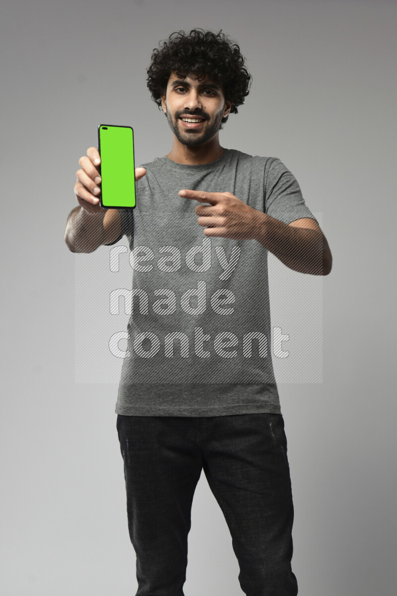 A man wearing casual standing and showing a phone screen on white background