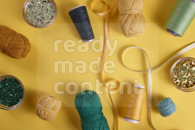 A green collection of sewing and tailoring tools arranged on a yellow background