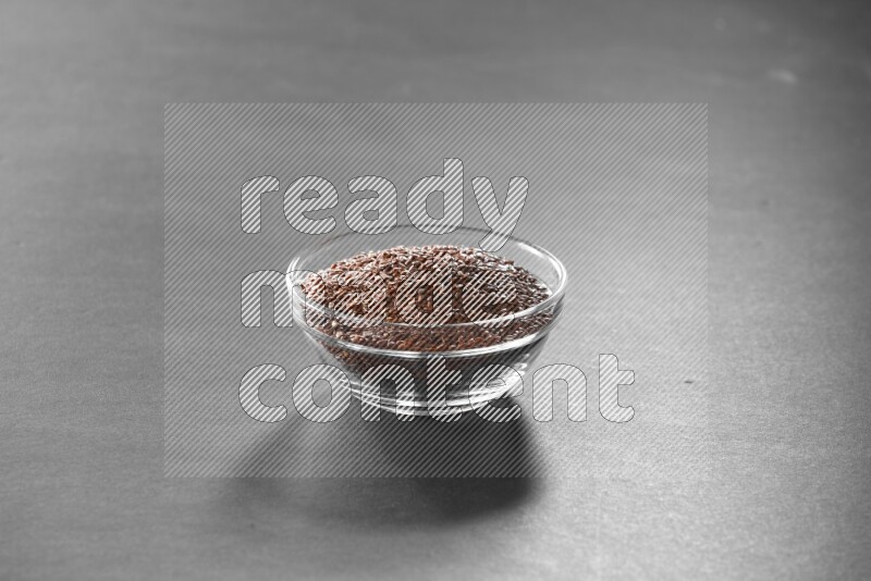 حبوب الكتان في وعاء زجاجي علي خلفية سوداء