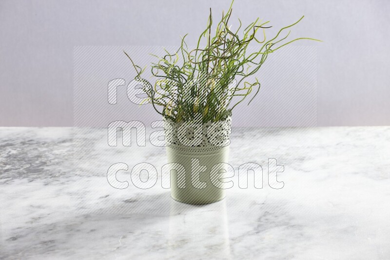Artificial plant in green decorative pot on grey marble background
