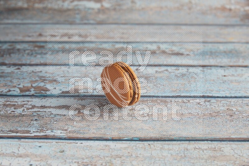 45º Shot of Brown Irish Cream macaron on light blue wooden background
