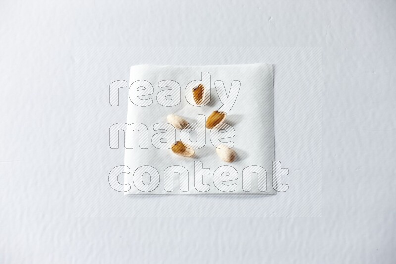 Pistachio peels on a piece of paper on a white background in different angles