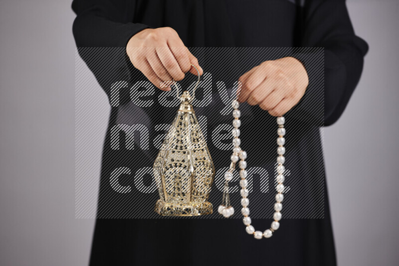 A woman in black abaya holding different ramadan lanterns in different positions
