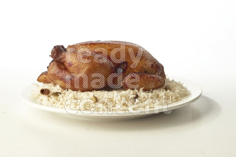 white  basmati Rice with  whole roasted chicken  on a white rounded plate direct on white background