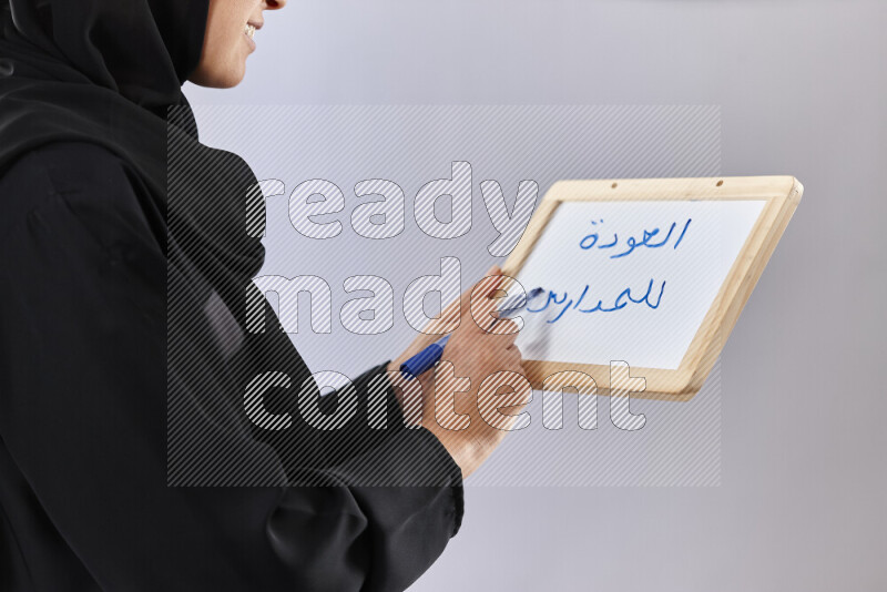 امرأة ترتدي عباءة تحمل كتب ولوح للكتابة في أوضاع متعددة (العودة إلى المدرسة)